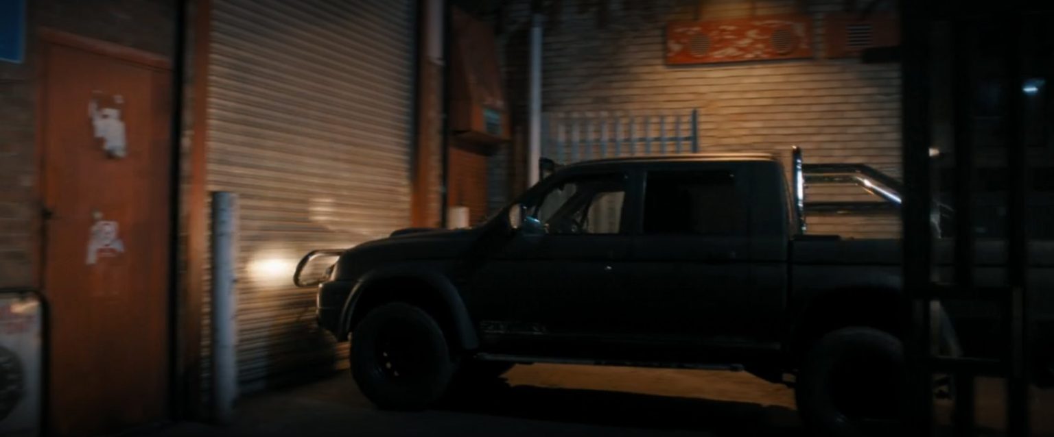 The STC Storm Edition L200 side-on in the yard at night, a still from MobLand