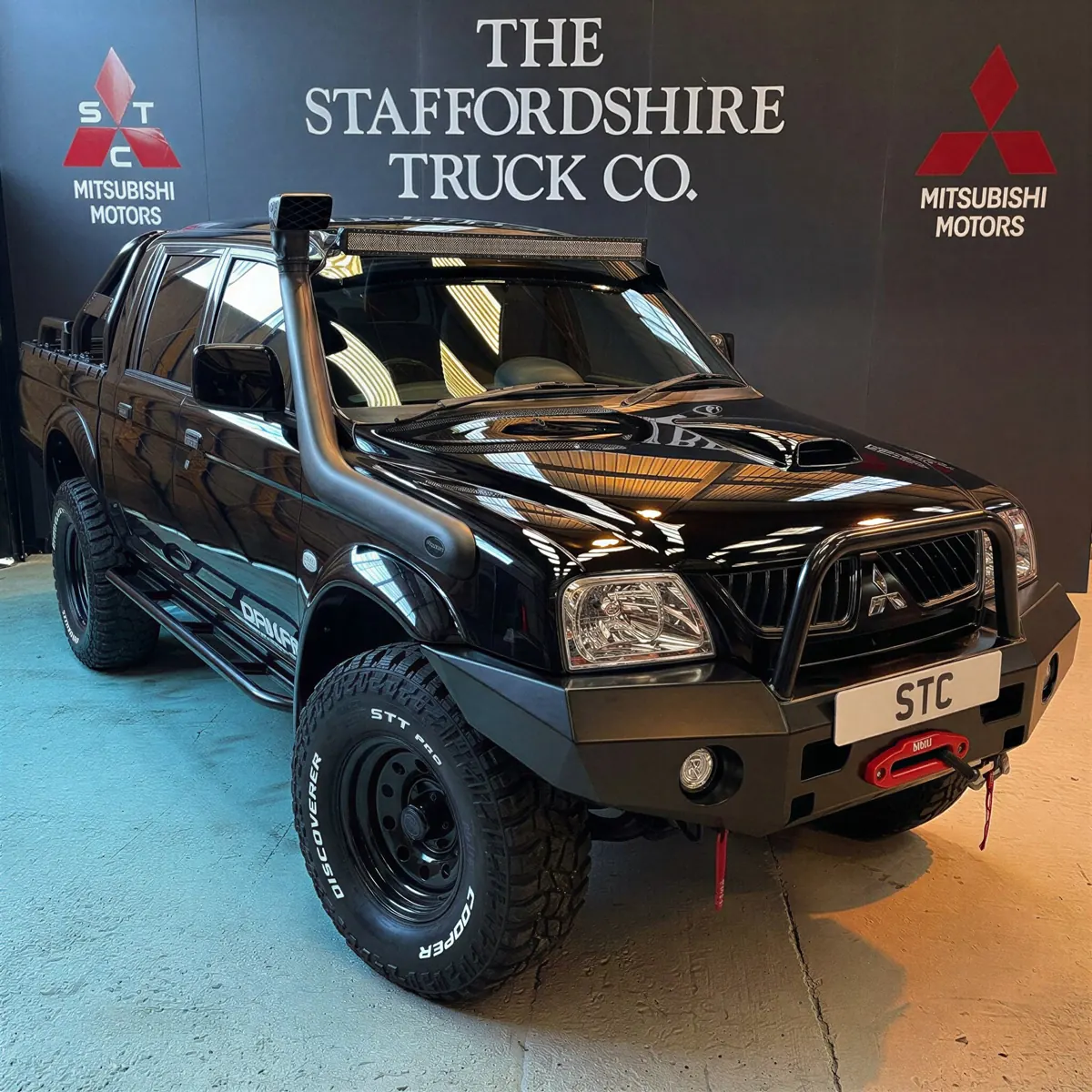 A black STC Dakar Pro Edition L200 with winch bumper in the studio