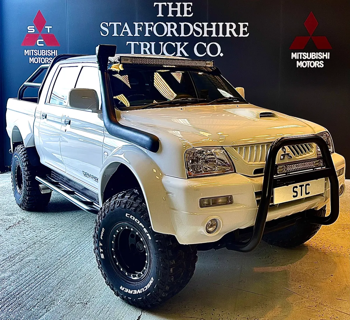 A white wide-body STC Dakar X Edition L200 in the studio