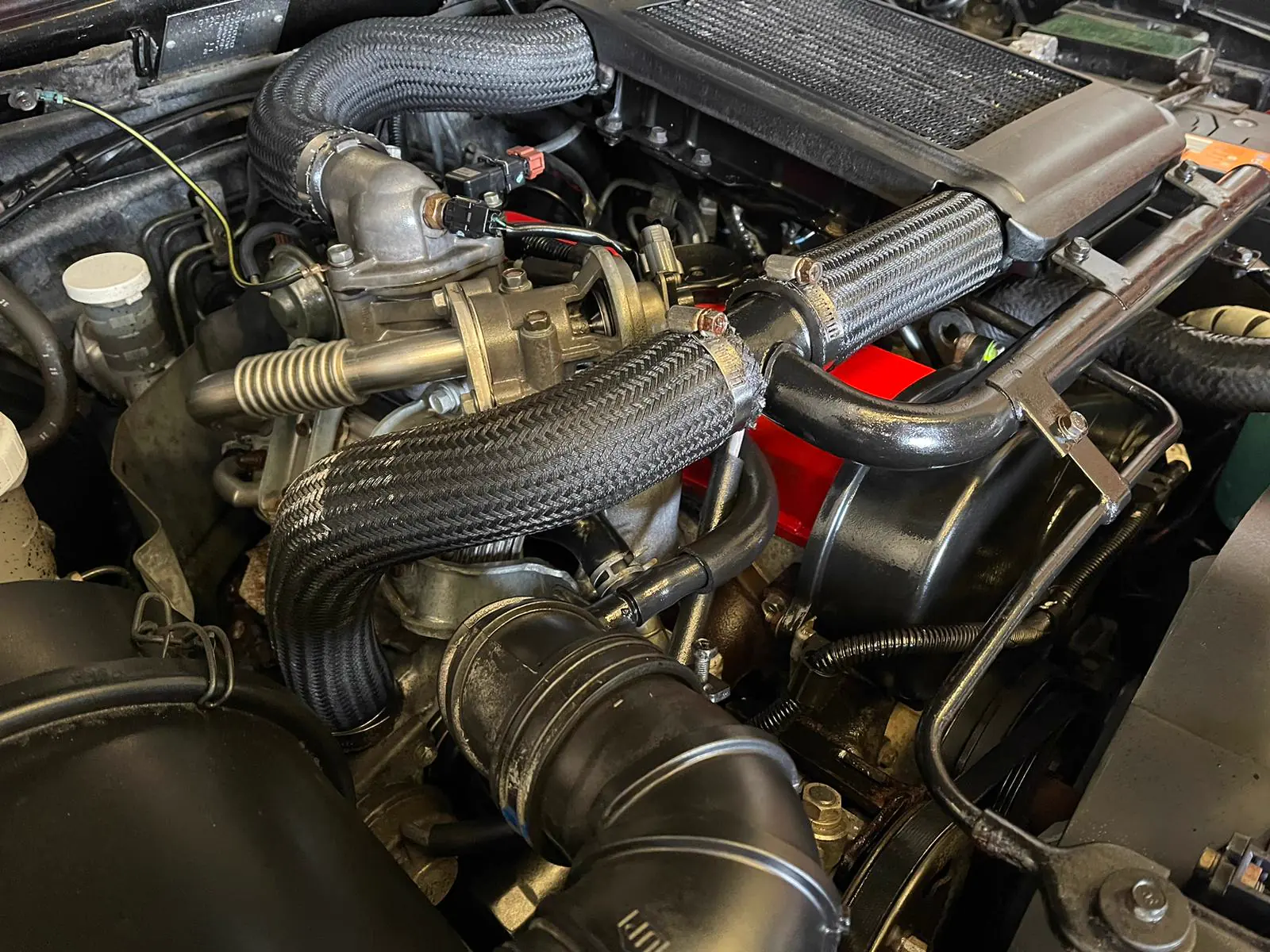 A finished STC Red Top 4D56 engine, red rocker cover, fitted in a K74 engine bay