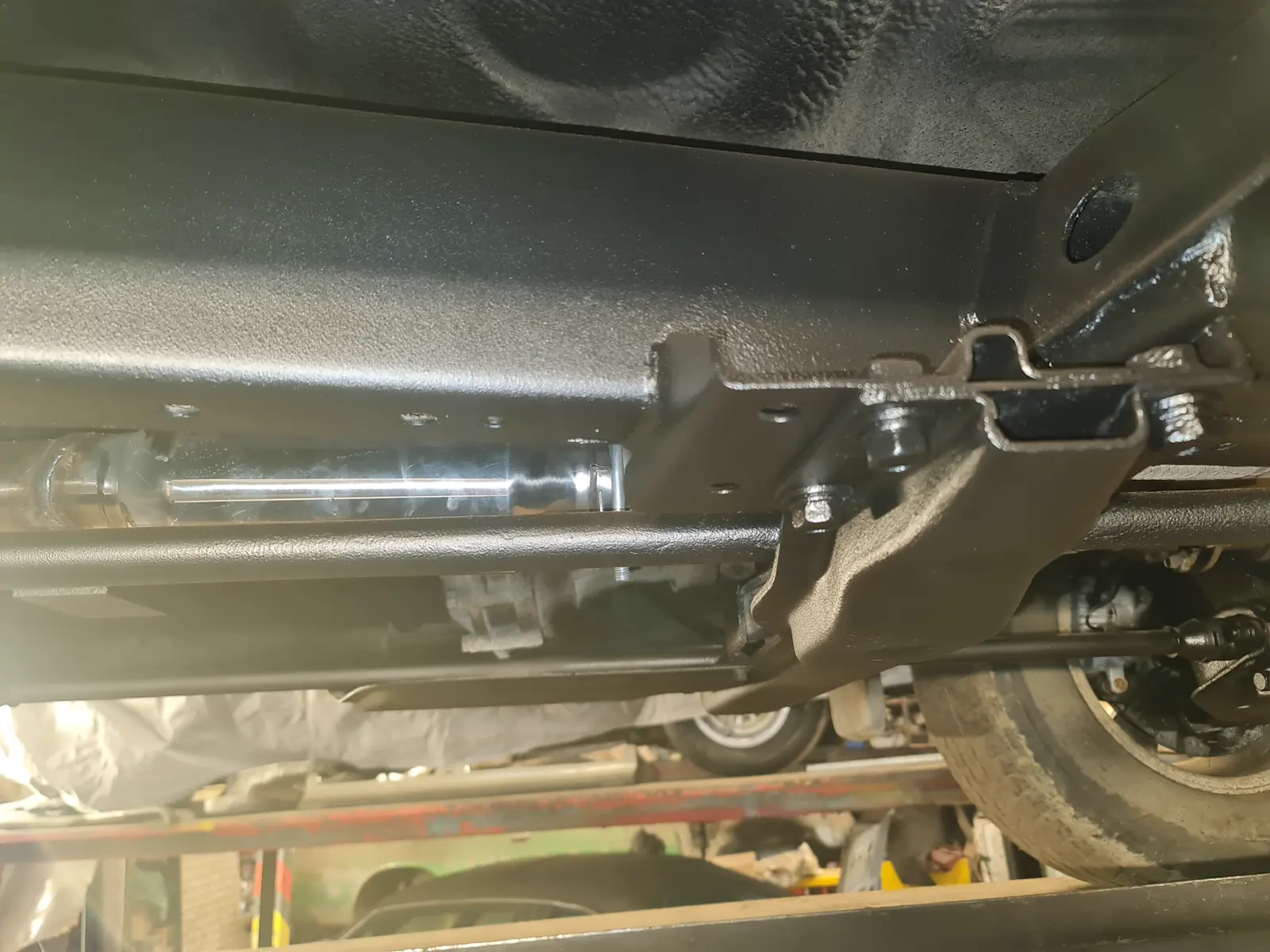 A freshly coated Mitsubishi L200 chassis rail and bracket seen from underneath