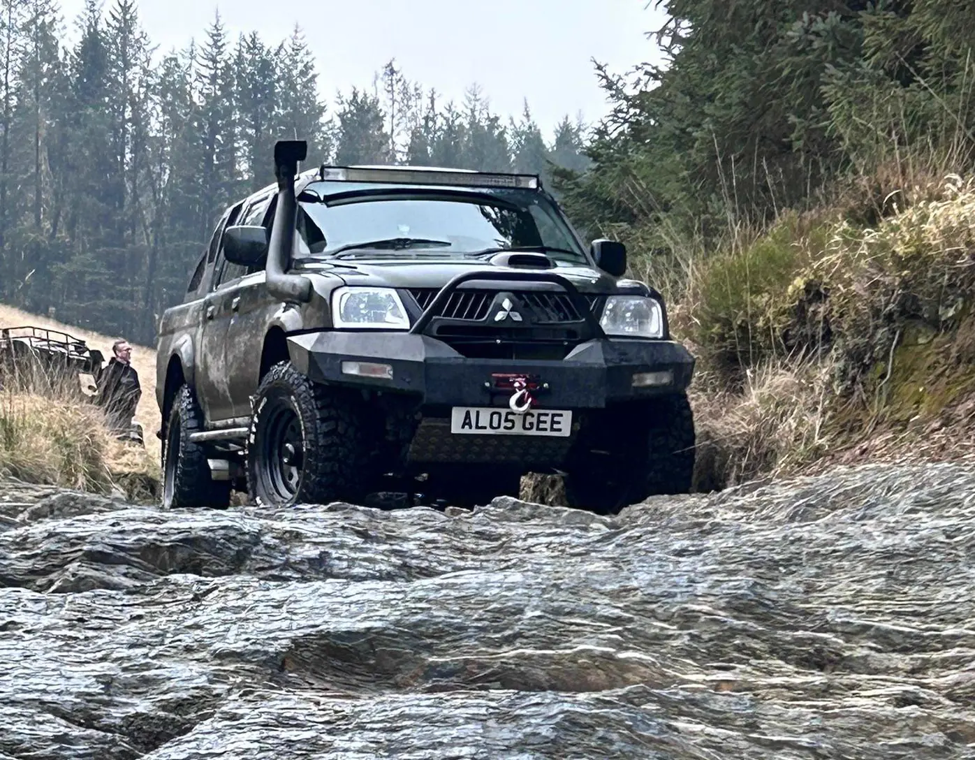 An owner&rsquo;s black Dakar Edition crossing a stream