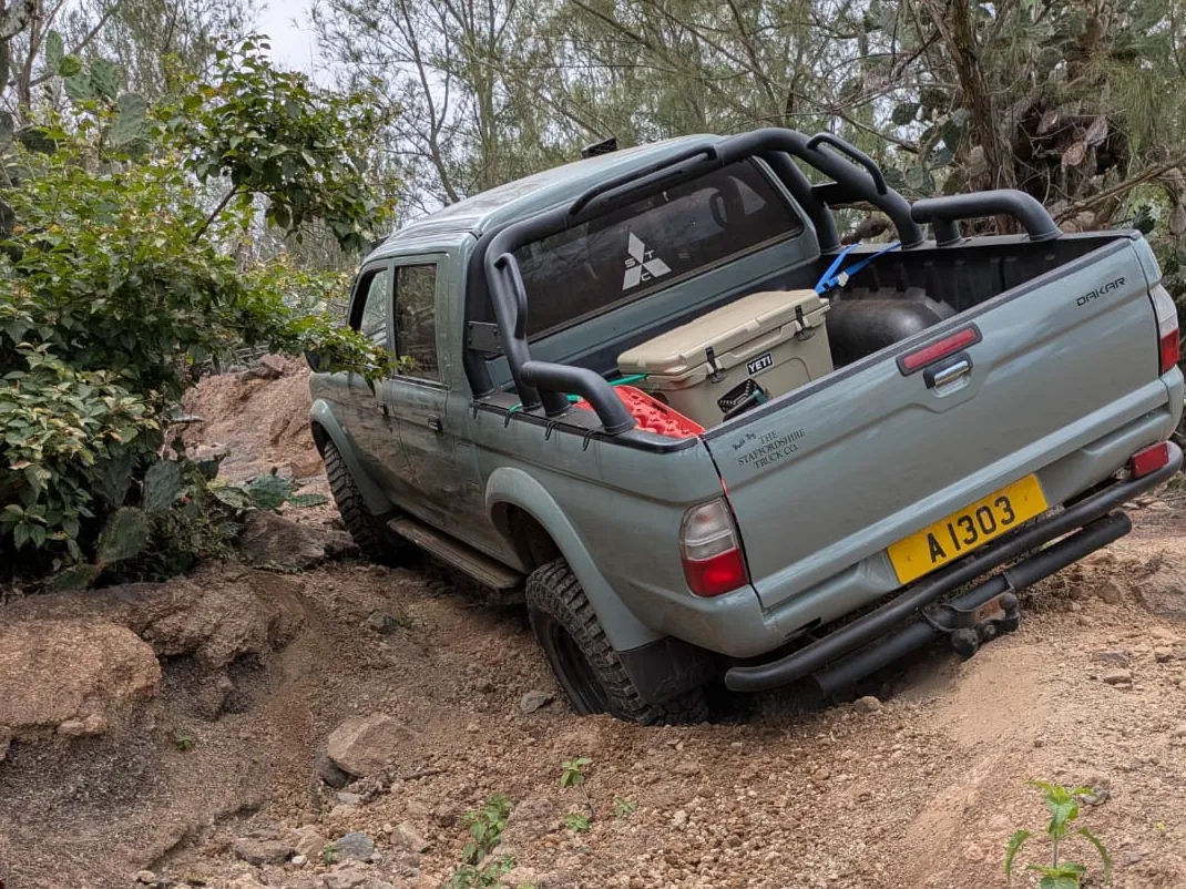 The Dakar climbing out of a deep rut between cactus