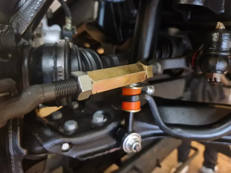 New suspension components fitted under an L200, red bushes and fresh steel