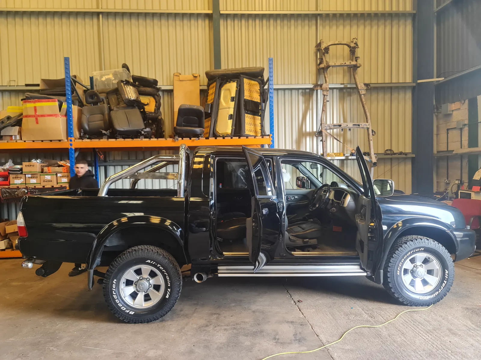 A black L200 K74 in the STC workshop, parts racked behind it