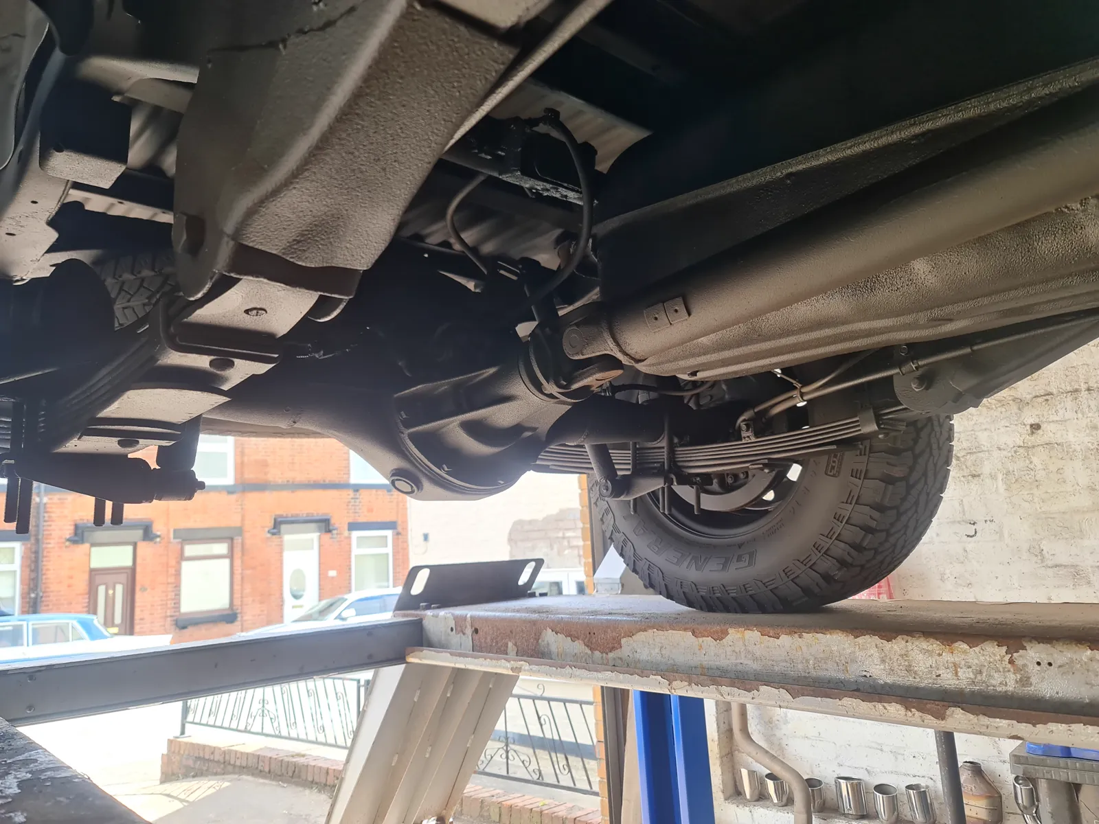 The underside of a Mitsubishi L200 K74 on the ramp, chassis and suspension in view